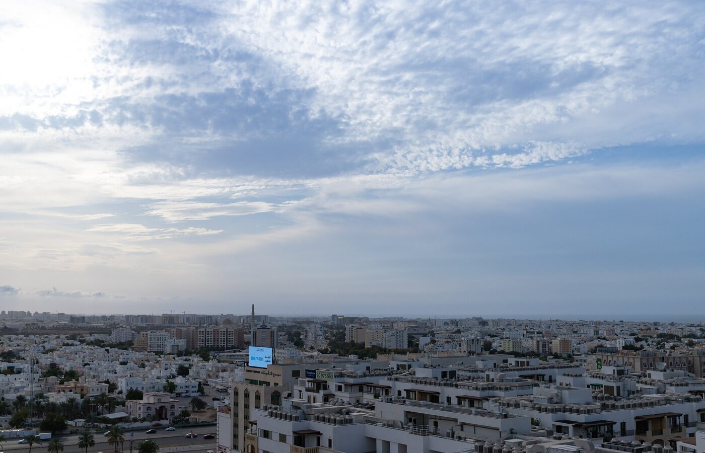 Aerial view over the low white housing of Muscat