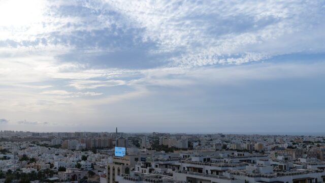 Aerial view over the low white housing of Muscat