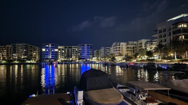Apartment buildings lit up at night around Al Mouj Marina, Muscat